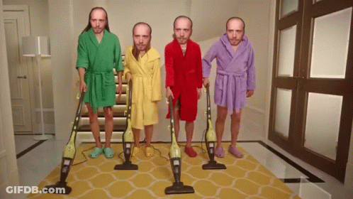 Four Men In Bathrobes Are Holding Vacuum Cleaners In A Hallway GIF