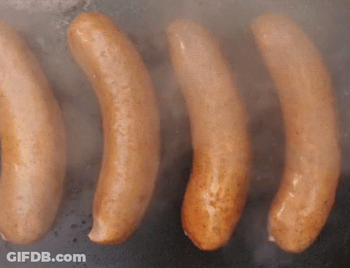 Four Sausages Are Being Cooked On A Grill And Smoke Is Coming Out Of Them GIF