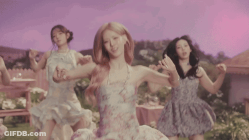 Four Women Are Dancing In Front Of A House In A Garden GIF