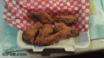 Fried Chicken Wings In A Styrofoam Container On A Checkered Paper GIF