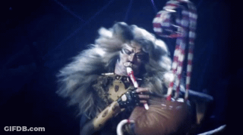 Furry Man Playing Flute In Dark Room GIF