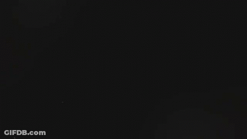 Gal Surrounded By Smoke In Dark Room GIF