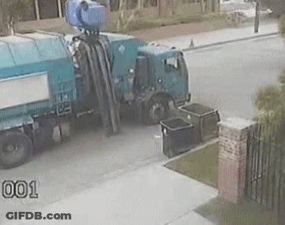 Garbage Truck Parked Next To Brick Wall GIF