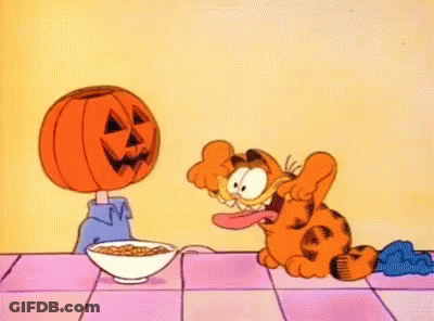 Garfield Sitting At Table With Cereal And Pumpkin Head GIF