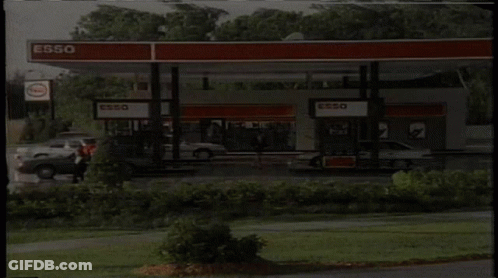Gas Station With Cars And Esso Sign GIF