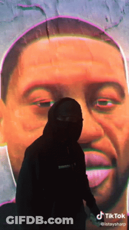 George Floyd Poster Behind Person In Jacket GIF