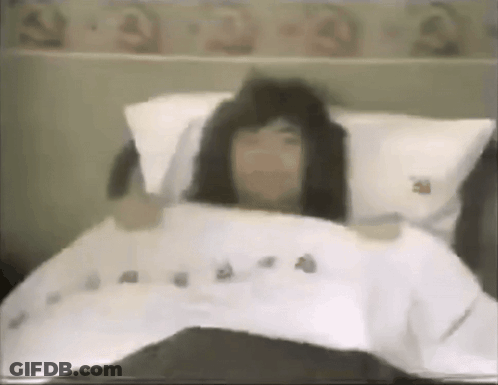 Ghost In White Cloth Sitting On Rug Beside Chair And Window GIF