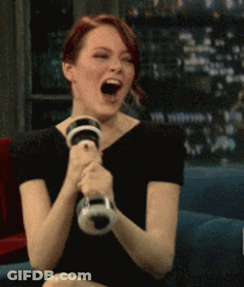 Giggly Emma Stone Shaking A Dumbbell GIF