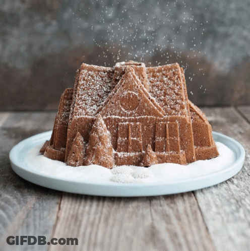 Gingerbread House Cake Covered In Powdered Sugar GIF