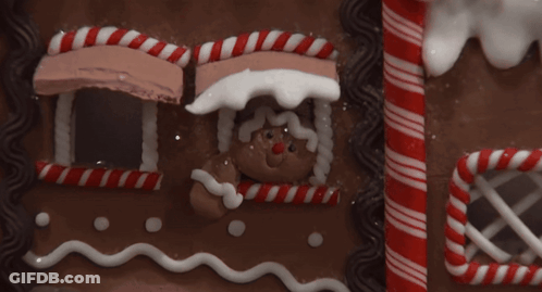 Gingerbread House With Candy Canes And Man GIF
