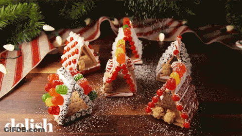 Gingerbread Houses Made Out Of Graham Crackers And Candy Are On A Table With The Word Delish In The Corner GIF