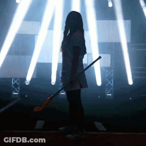Girl Holding Lacrosse Stick In Front Of Cross Sign GIF