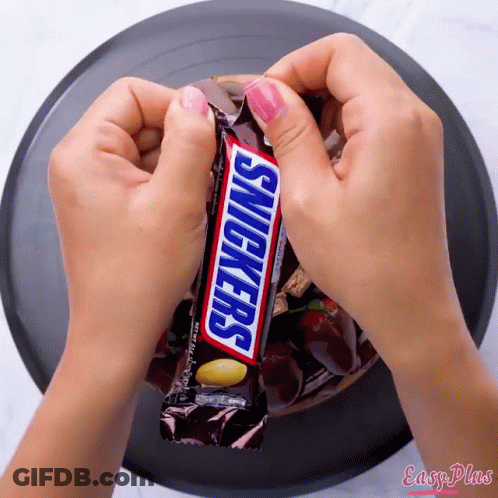Girl Holding Snickers Bar Another Says Have A Snickers GIF