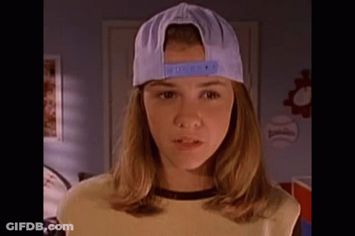 Girl In Baseball Cap And Yellow Shirt Standing In Room GIF