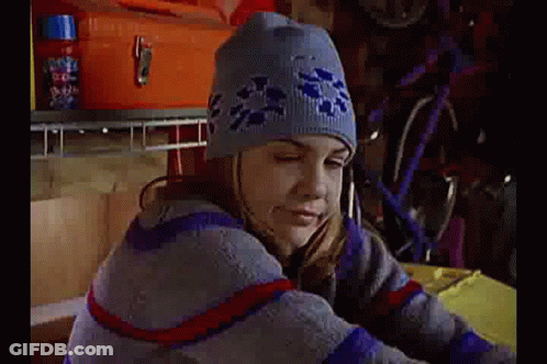 Girl In Beanie And Sweater Sitting At Table GIF