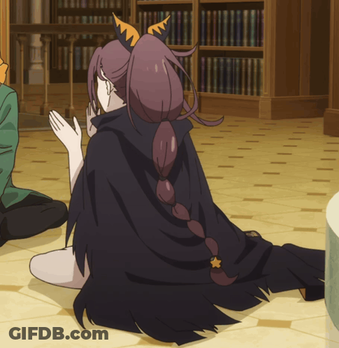 Girl In Black Cape Sitting On Floor GIF