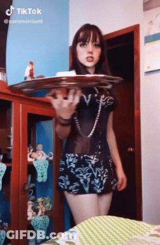 Girl In Black Dress Holding Tray GIF