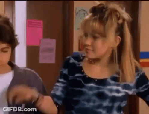 Girl In Blue Dress Next To Boy In Hallway GIF
