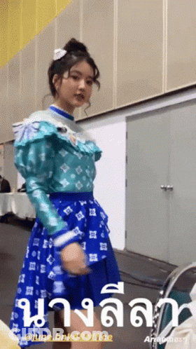 Girl In Blue Dress Standing In Front Of June BNK48 Office Sign GIF