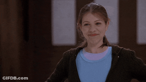 Girl In Blue Shirt And Brown Sweater Smiling GIF