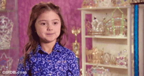Girl In Blue Shirt In Front Of Crowns GIF