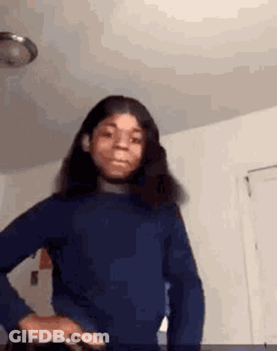 Girl In Blue Sweater Standing In Room GIF