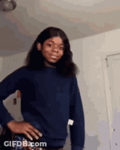 Girl In Blue Sweater Standing With Hands On Hips GIF