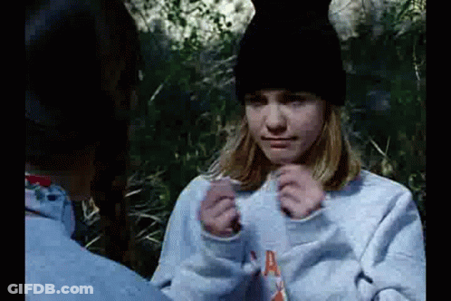 Girl In Blue Sweatshirt And Black Hat Sitting Next To Man GIF