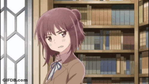 Girl In Brown Suit In Front Of Bookcase GIF