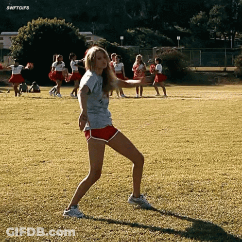 Girl In Gray Shirt And Red Shorts Dancing On Field GIF