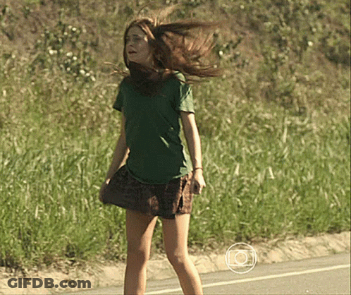 Girl In Green Shirt And Plaid Skirt Standing On Road GIF