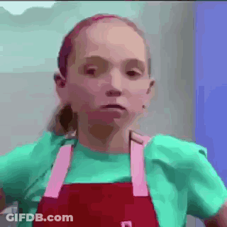 Girl In Green Shirt And Red Apron Making Funny Face GIF