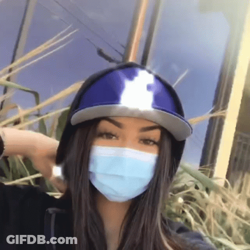 Girl In Hat And Mask Standing In Grass GIF