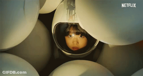 Girl In Helmet Surrounded By White Balls GIF