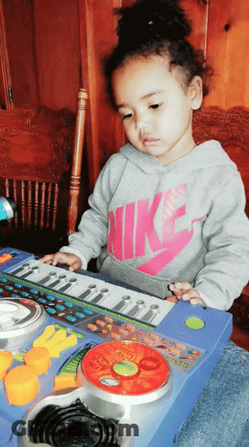Girl In Nike Shirt Playing Toy Keyboard GIF