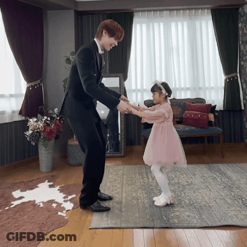 Girl In Pink Dress Holding Hands With Man In Suit GIF
