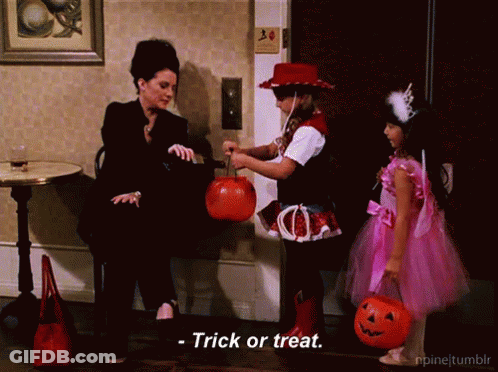 Girl In Pink Dress Holding Pumpkin Woman In Black Suit Says Trick Or Treat GIF