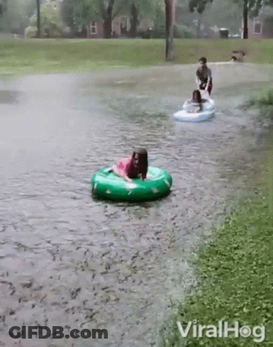 Girl In Pink Dress Riding Green Inner Tube GIF