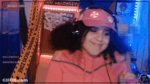 Girl In Pink Hat And Headphones In Front Of Halloween Warning Tape GIF