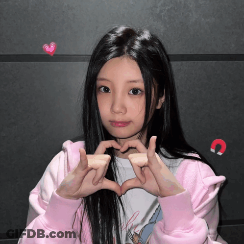 Girl In Pink Jacket Making Heart Shape GIF