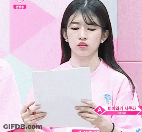 Girl In Pink Shirt Holding Paper With Letter A GIF