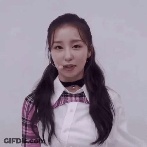 Girl In Plaid Shirt And Choker Looking At Camera GIF