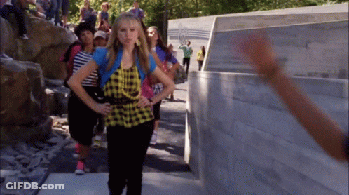 Girl In Plaid Shirt In Front Of Olympics Wall GIF