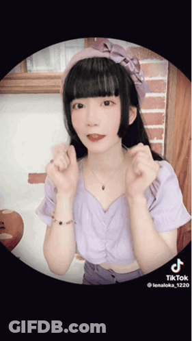 Girl In Purple Top With Pink Headband Making Heart Shape GIF