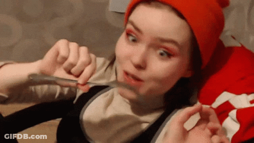 Girl In Red Hat Holding Spoon To Mouth GIF