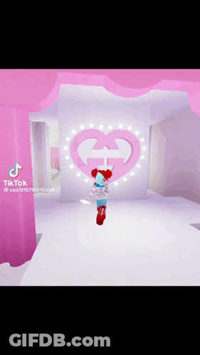 Girl In Red Hat Standing Before Pink Heart With G GIF