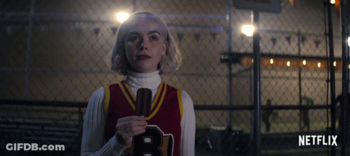 Girl In Red Jersey With Letter B Holding Microphone GIF