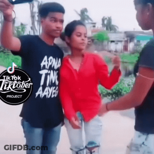 Girl In Red Shirt Next To Man In Black Shirt Saying TikTok GIF
