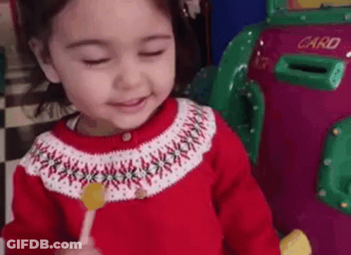 Girl In Red Sweater Holding Lollipop GIF