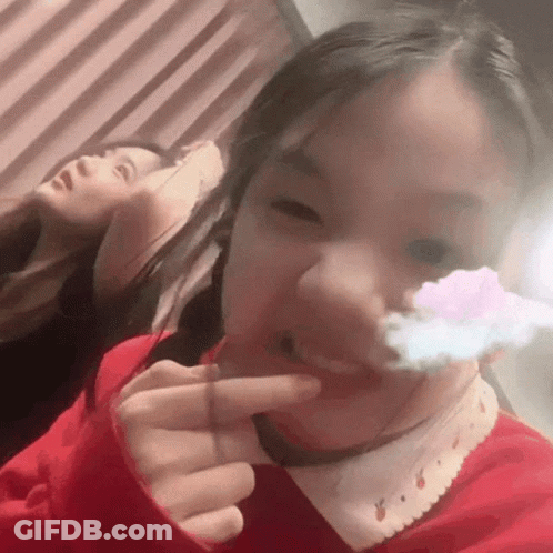 Girl In Red Sweater Making Funny Face With Finger In Mouth GIF